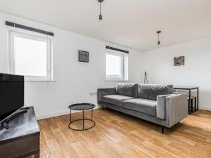 a living room with a couch and a table at Pass the Keys Central Modern Flat with Parking in Chichester
