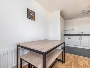 a kitchen with a wooden table in a room at Pass the Keys Central Modern Flat with Parking in Chichester