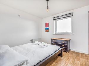 a bedroom with a bed and a dresser and a window at Pass the Keys Central Modern Flat with Parking in Chichester