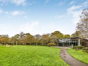 a building in a park with a grass field at Pass the Keys Central Modern Flat with Parking in Chichester