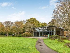 a building in a park with a path leading to it at Pass the Keys Central Modern Flat with Parking in Chichester