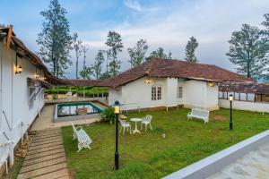 a house with a yard with chairs and a pool at Zostel Plus Wayanad in Kalpetta