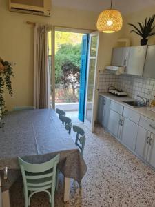 a kitchen with a table and chairs and a kitchen with a table and a window at Big apartment on the beach in Tolo