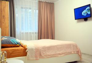 ein Schlafzimmer mit einem Bett und einem TV an der Wand in der Unterkunft BoHo Apartment near Center! in Chişinău