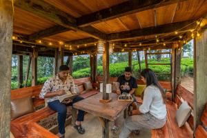 un grupo de personas sentadas en una mesa en una casa en Zostel Plus Wayanad, en Kalpetta