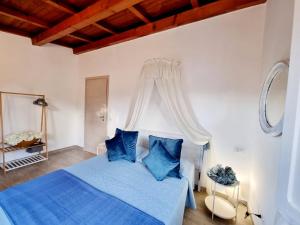 a bedroom with a blue bed with blue pillows at Stazzo San Teodoro in San Teodoro