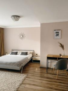 een slaapkamer met een bed en een bureau bij Апартаменти в центрі Тернополя in Ternopilʼ