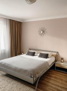 - une chambre avec un lit et un lustre au-dessus dans l'établissement Апартаменти в центрі Тернополя, à Ternopil