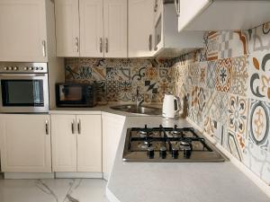 a kitchen with a stove top and a sink at Апартаменти в центрі Тернополя in Ternopil
