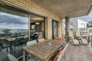 a patio with a wooden table and chairs on a balcony at Roses Frontline perfect for family in Roses