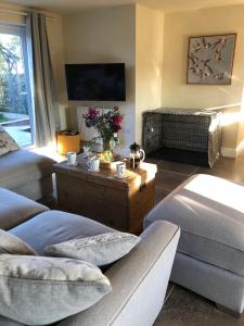 a living room with a couch and a table with flowers at Luxury 5 bedroom house - sleeps 10 in Colkirk