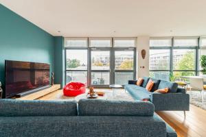 un soggiorno con 2 divani blu e un camino di Luxurious flat sunny, quiet, design, lift, balcony a Londra
