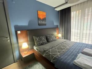 1 dormitorio con cama y pared azul en wide garden flat close to the memorıall hospital hGyhomes2103, en Estambul