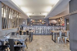 een restaurant met tafels en stoelen en een bar bij L'Oree du Bois in Font-Romeu