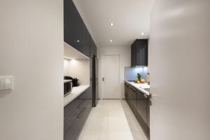 a kitchen with black cabinets and white counters at Kolonaki 2 Bdr apartment in Athens