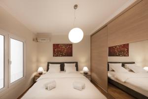 a bedroom with two beds and a large window at Kolonaki 2 Bdr apartment in Athens