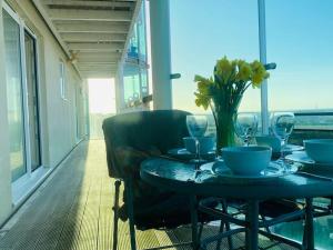 Una mesa con un jarrón de flores en un balcón. en Seascape Apartment, en Portland