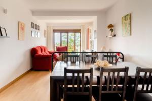 ein Wohnzimmer mit einem Tisch und Stühlen in der Unterkunft Casa de Las Flores - Apartamento con jardín privado frente a la Playa de Comillas in Comillas