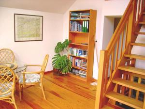 ein Wohnzimmer mit einer Treppe und einem Bücherregal in der Unterkunft Maison de vacances familiale: le Petit Nid Mosan in Dinant