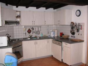 una cocina con armarios blancos y fregadero en Maison de vacances familiale: le Petit Nid Mosan, en Dinant