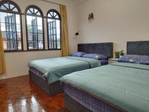 2 camas en una habitación con 3 ventanas en Grand Height Homestay 7A 10pax 4Rooms, en Sibu