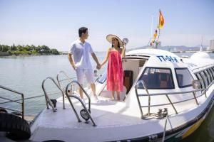 un hombre y una mujer de pie en un barco en Vinpearl Resort & Spa Ha Long, en Ha Long