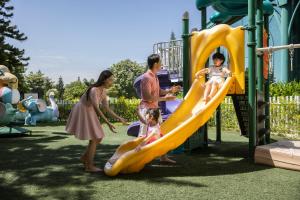 una familia jugando en un tobogán en un parque infantil en Vinpearl Resort & Spa Ha Long, en Ha Long