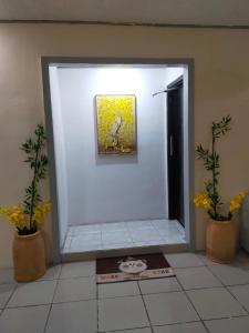 a white room with a painting on the wall and two plants at 4 bedroom 2 bath house in Angeles