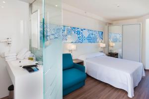 ein Hotelzimmer mit einem Bett und einem blauen Stuhl in der Unterkunft Port Benidorm Hotel & Spa 4* Sup in Benidorm