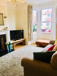 a living room with a couch and a television at Spacious Victorian townhouse with Cathedral views in Lincoln