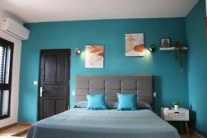 een slaapkamer met blauwe muren en een bed met blauwe kussens bij Apartamentos La Carmen in Arrecife