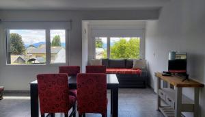 sala de estar con sofá, mesa y sillas en Departamento con vista al lago y cerros en San Carlos de Bariloche