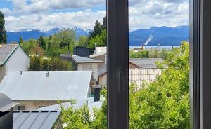 desde una ventana de una ciudad con montañas en Departamento con vista al lago y cerros en San Carlos de Bariloche