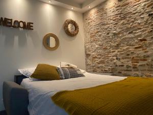 a bedroom with a bed and a stone wall at Exceptionnel ! Superbe appartement refait à neuf en rez-de-chaussée avec parking privé in Castres