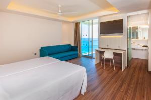 Habitación de hotel con cama, sofá y TV en Port Benidorm Hotel & Spa 4* Sup en Benidorm