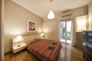 um quarto com uma cama, uma cómoda e uma janela em Artistic apartment next to everything em Atenas