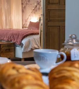 Cette chambre comprend un lit et une table avec du pain. dans l'établissement La Chambre Enchantée, à La Baffe