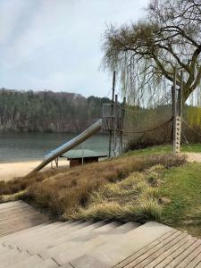 a slide on the side of a beach next to the water at Neues-Ferienhaus-am-schoenen-Ferienpark-Twistesee-Naehe-Bad-Arolsen in Bad Arolsen