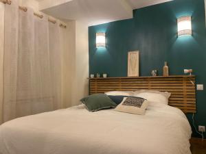 a bedroom with a large white bed with blue walls at Exceptionnel ! Superbe appartement refait à neuf en rez-de-chaussée avec parking privé in Castres