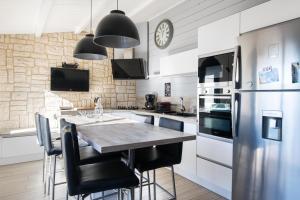 a kitchen with a table and a refrigerator at CAP O SUD grande maison avec Piscine à St Martin de Ré in Saint-Martin-de-Ré