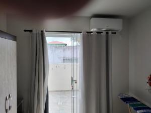 a bathroom with a shower curtain and a window at Apê aconchegante in São José +11 photos
