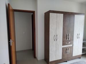 a bedroom with a wooden dresser and a door at Apê aconchegante in São José