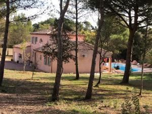 卡爾卡松的住宿－Le Mas Victoria - Chambres d'hôtes avec table d'hôtes，粉红色的房子,设有游泳池和树木