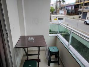 a balcony with a table and two stools at Apê aconchegante in São José
