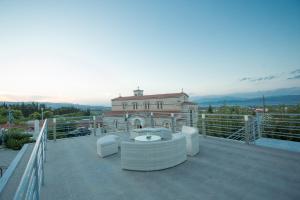 einen Balkon mit weißen Möbeln und ein Gebäude in der Unterkunft Apollonio Upper View Suites in Korinthos