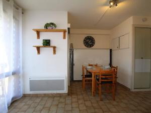 een eetkamer met een tafel en stoelen en een klok bij Appartement Briançon, 1 pièce, 2 personnes - FR-1-330C-47 in Briançon