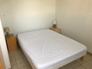 ポール・ルカートにあるAppartement Port Leucate, 3 pièces, 5 personnes - FR-1-81-90のベッドルーム1室(白いベッド1台、ナイトスタンド2台付)