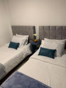 dos camas sentadas una al lado de la otra en una habitación en Confortable Apartaestudio, en Bogotá