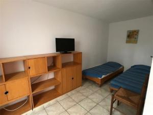 Cette chambre dispose d'une télévision et d'un bureau avec un lit. dans l'établissement Appartement Port Leucate, 3 pièces, 6 personnes - FR-1-81-83, à Port-Leucate