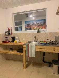 a kitchen with a sink and a counter with a window at Confortable Apartaestudio in Bogotá